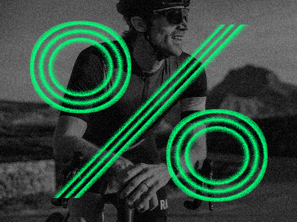 Cyclist leaning on the handlebars of a bicycle with a large green percentage symbol overlaying the image