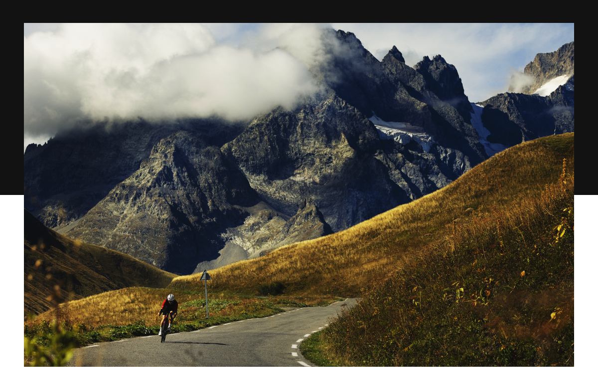 Cyclist riding through dramatic mountain landscape