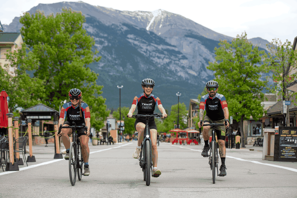 A heavily pixelated photo of a cyclist riding past mountains, slowly resolving to reveal the scene.